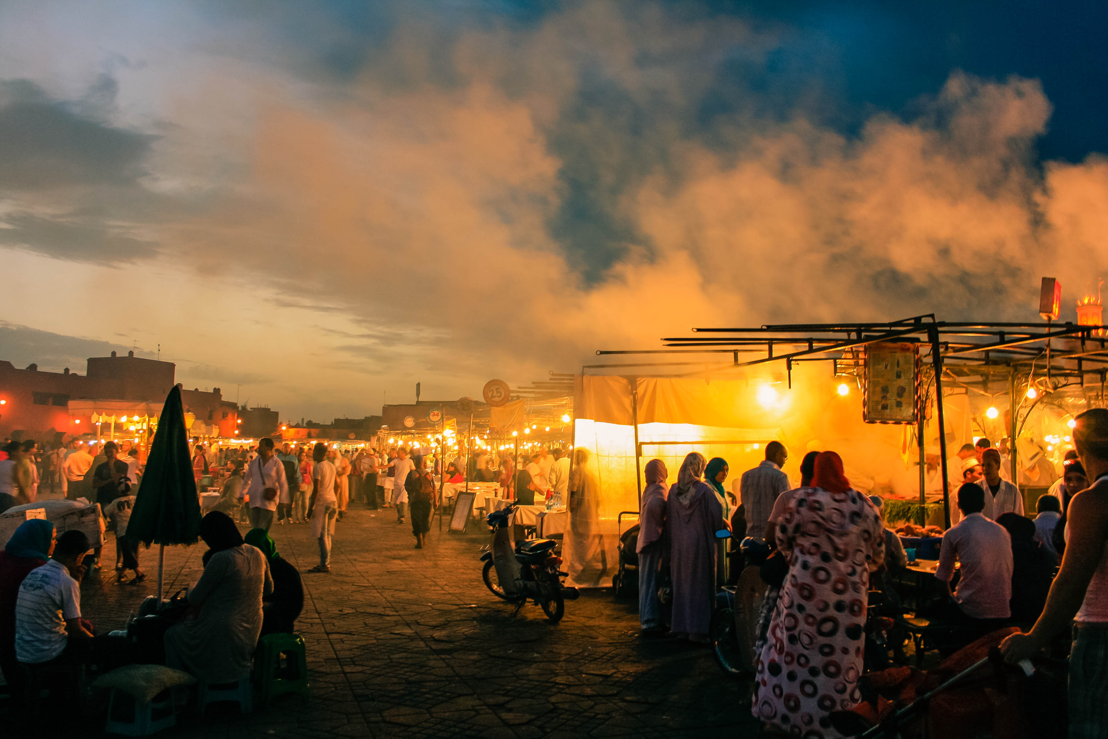 Large groups of people in an open air market.