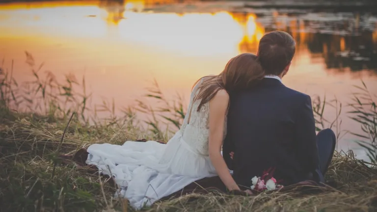 A young married couple hugging each other.